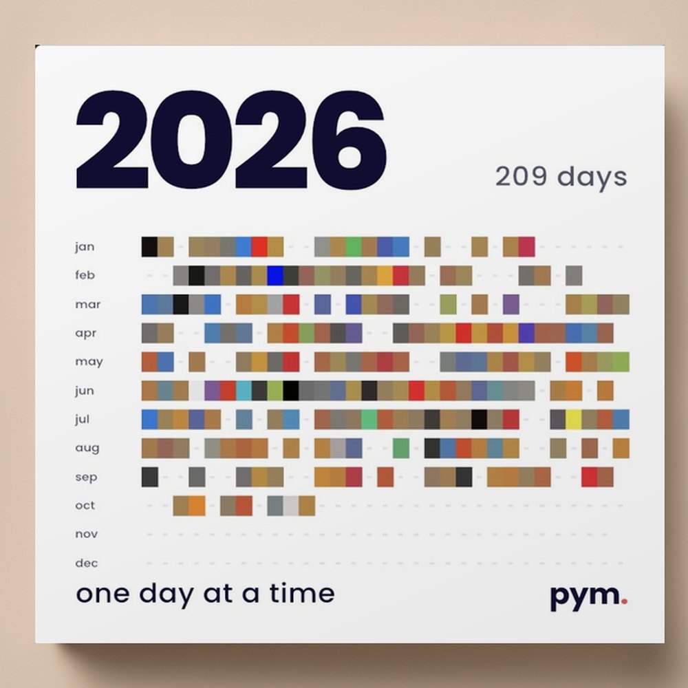 A printed PYM yearbook for 2026, photos set into the digits of the cover, on a studio table